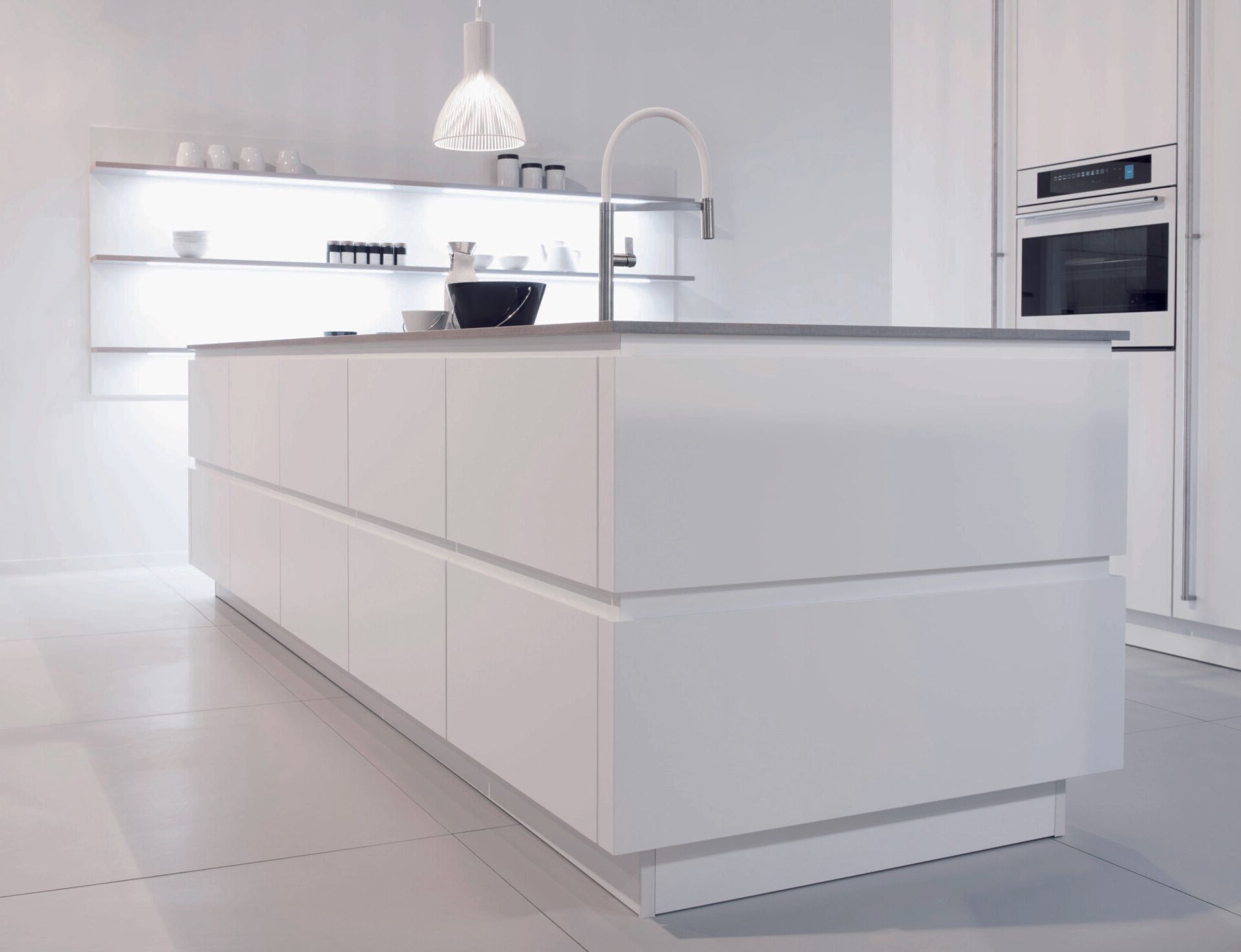 Een witte keuken met een groot kookeiland in het midden