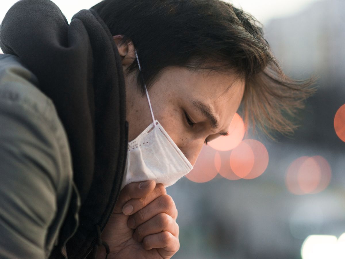 A man displaying bird flu symptoms, which include persistent coughing.