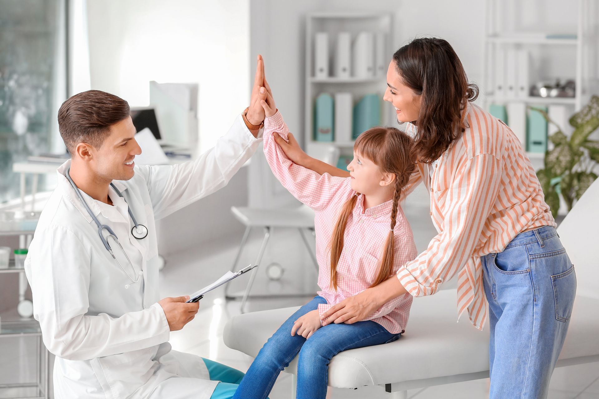 Family medicine doctor attending to mother and daughter