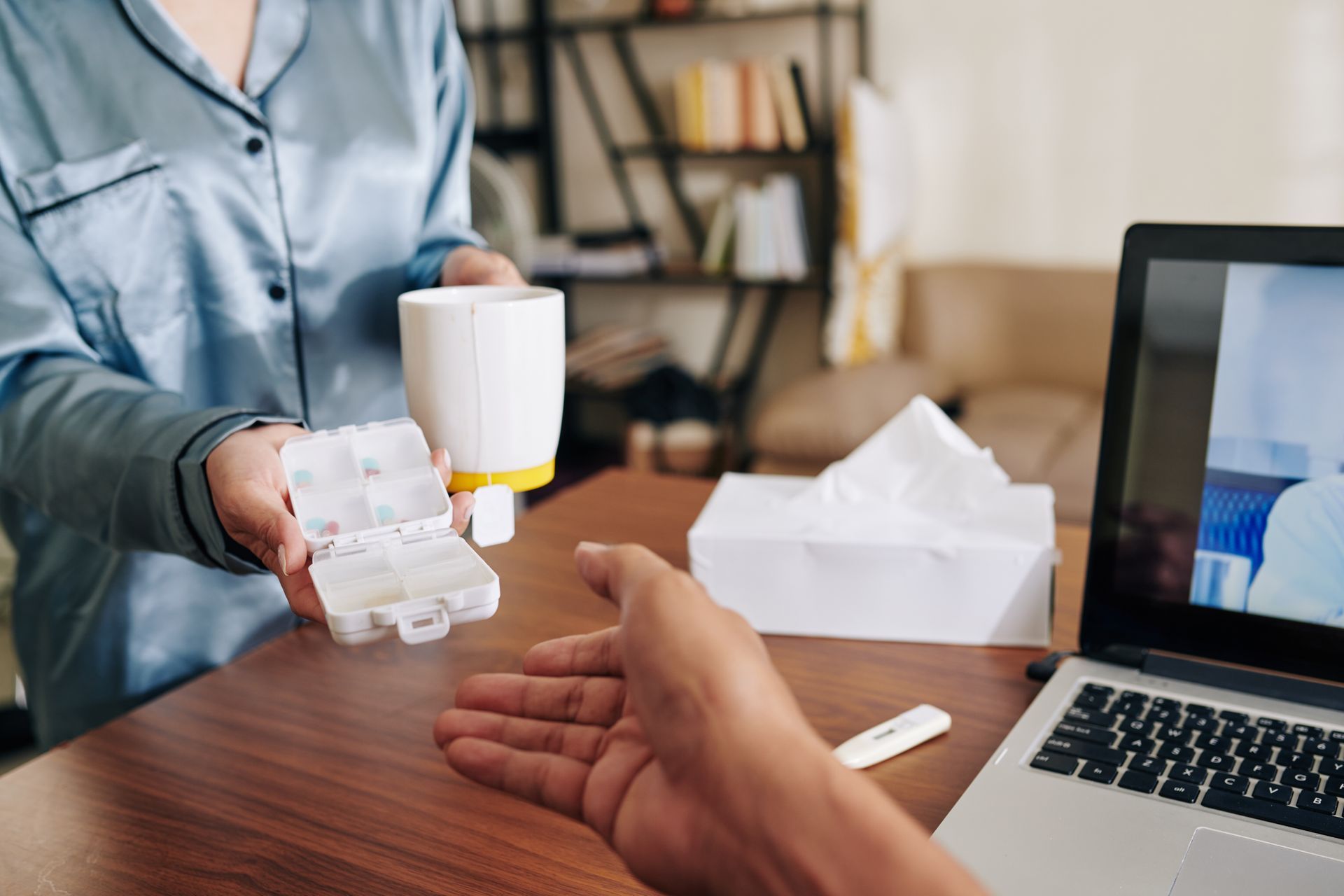 A caregiver ensures drug adherence by handing medicine to a patient