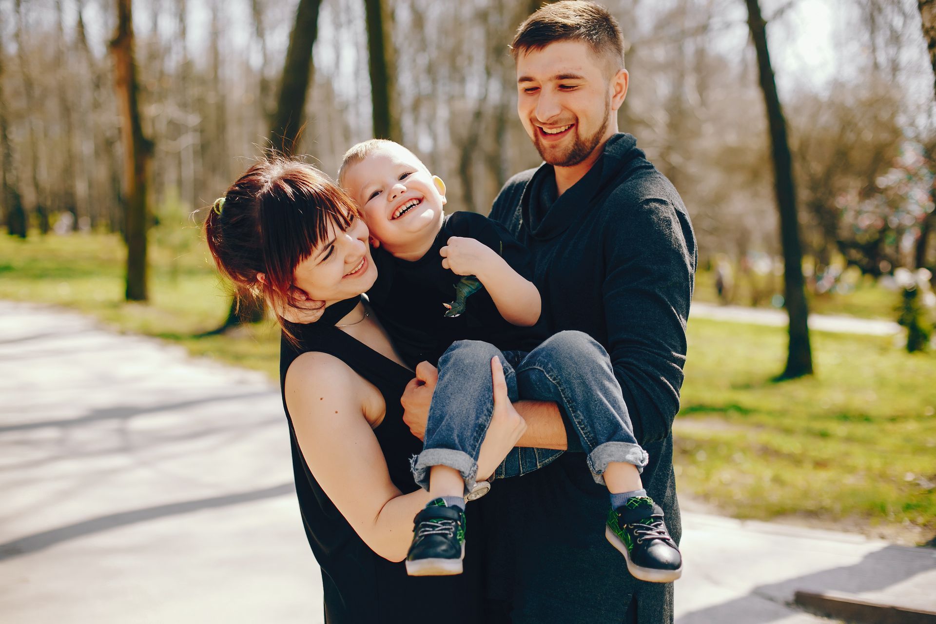 While managing children’s allergies effectively, a young couple enjoys time outdoors with their toddler.
