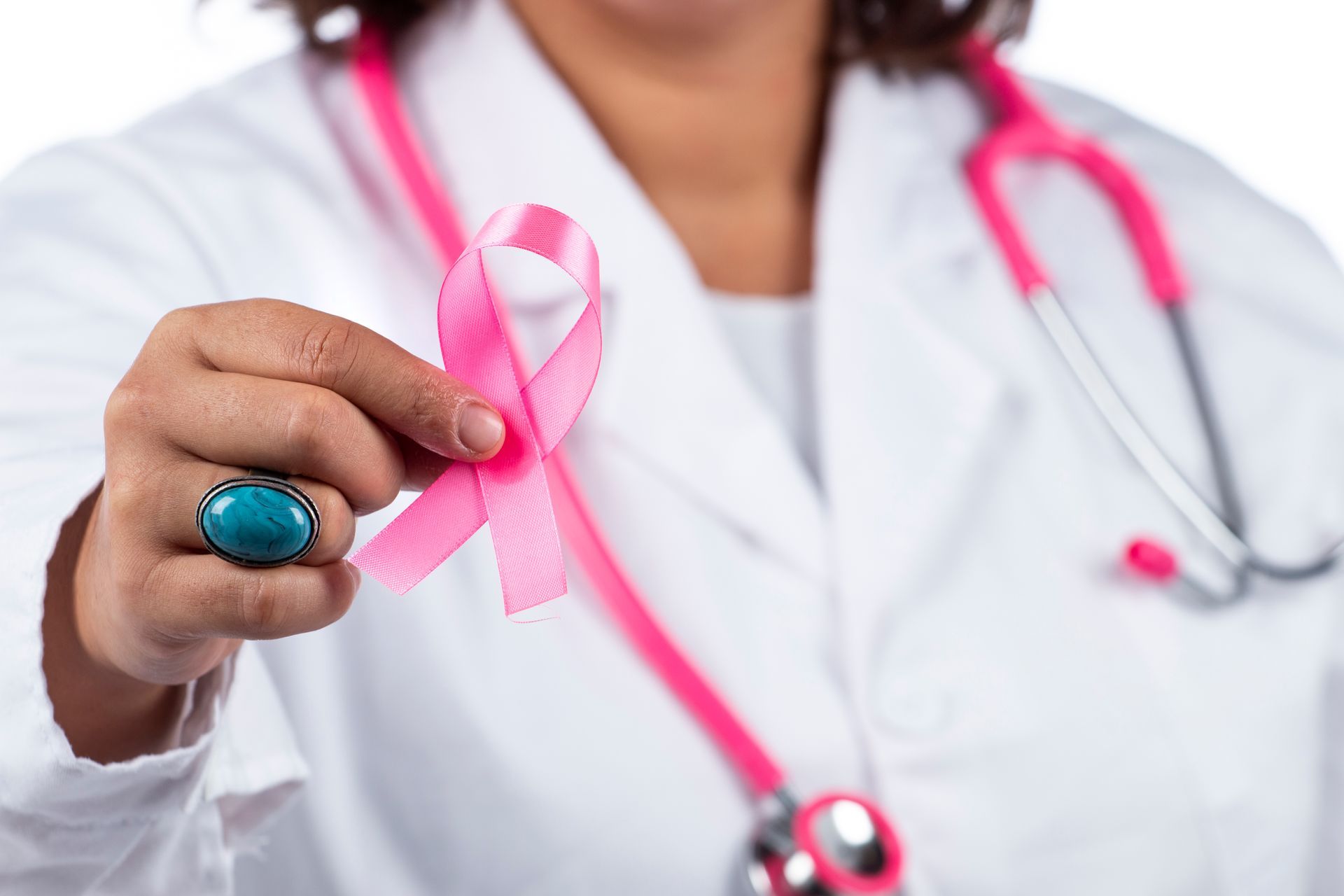 A doctor holding the pink ribbon symbol for breast cancer while giving tips and spreading awareness