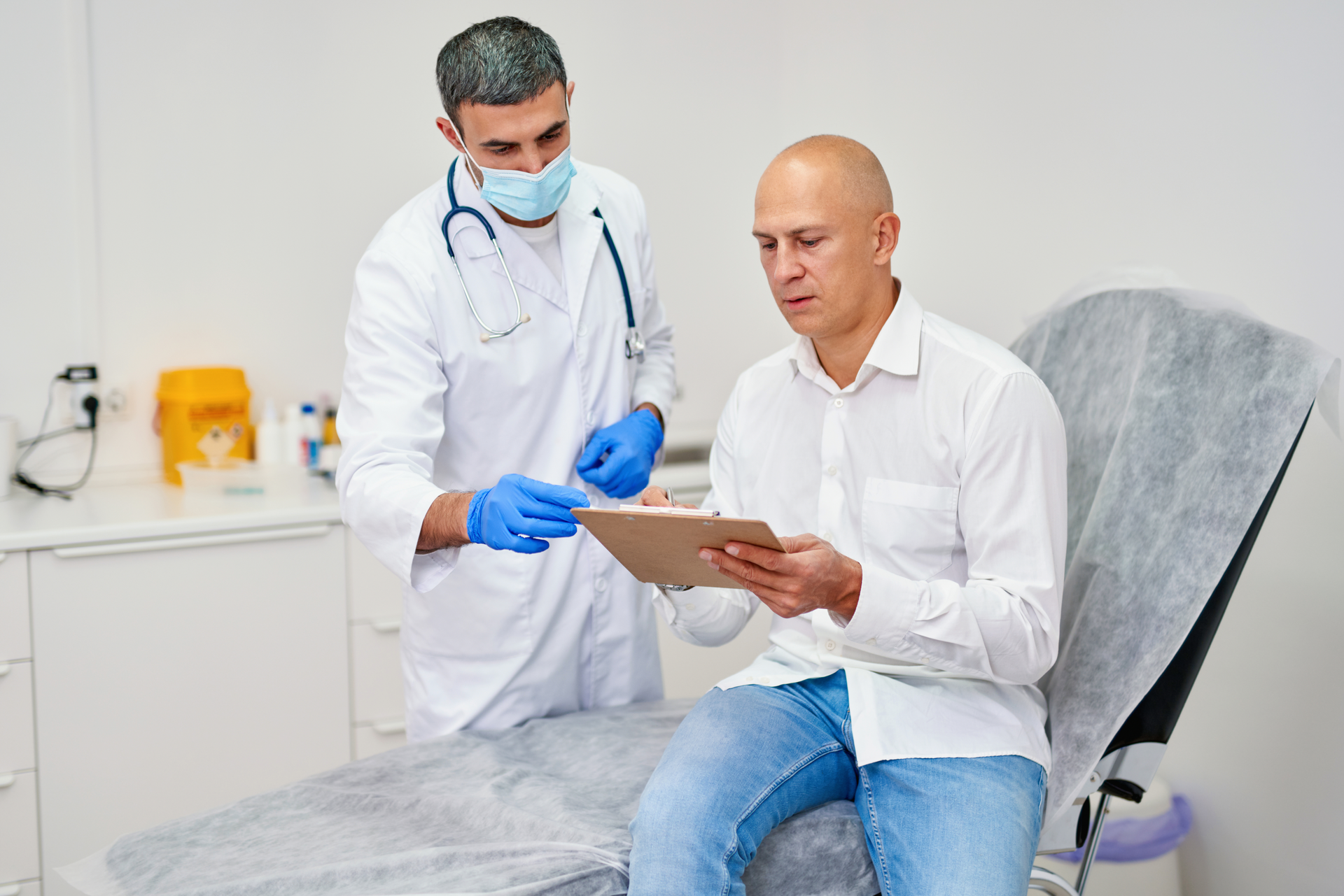 A man taking a health screening test with a healthcare professional guiding him