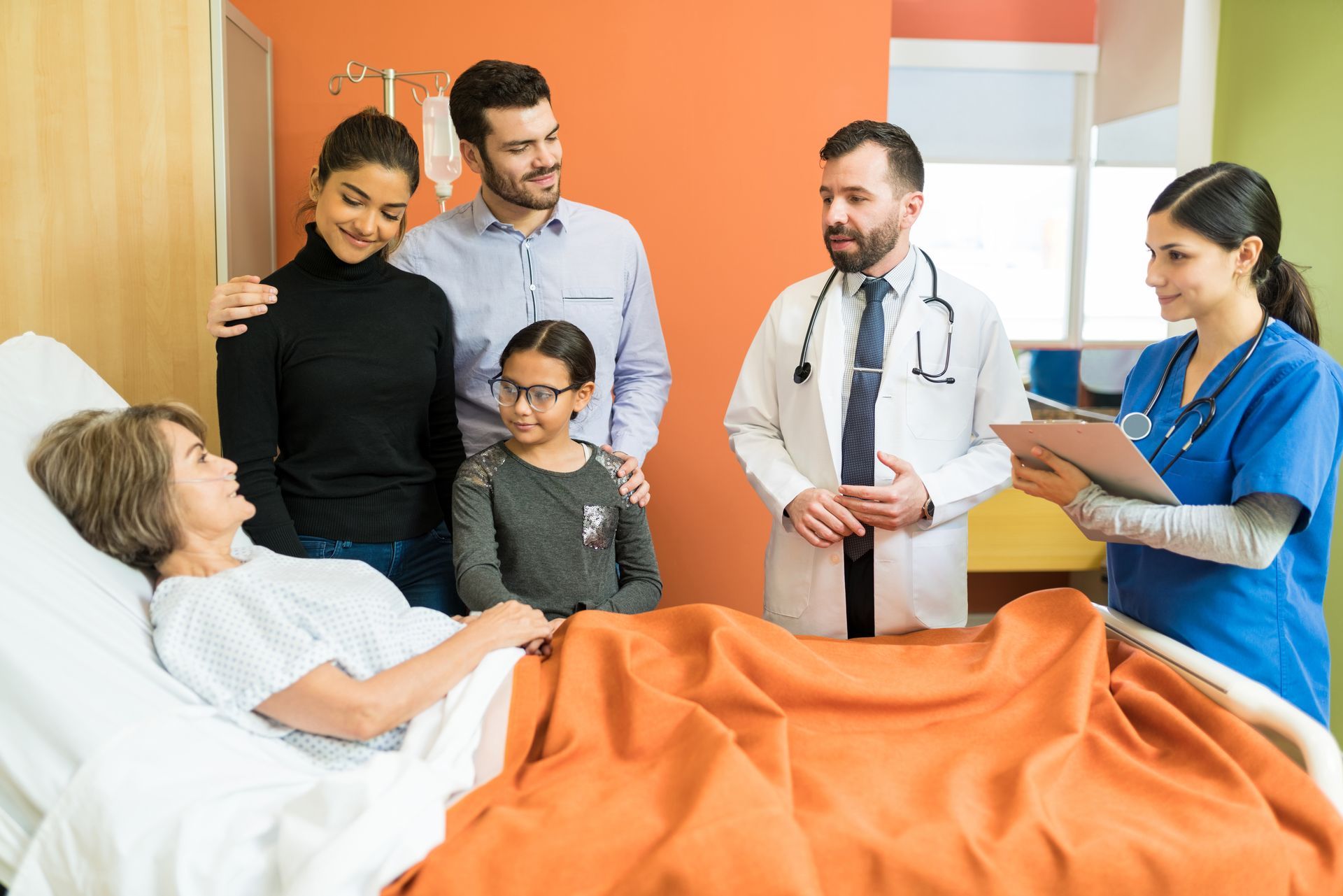 A family doctor treats an elderly patient surrounded by family. 