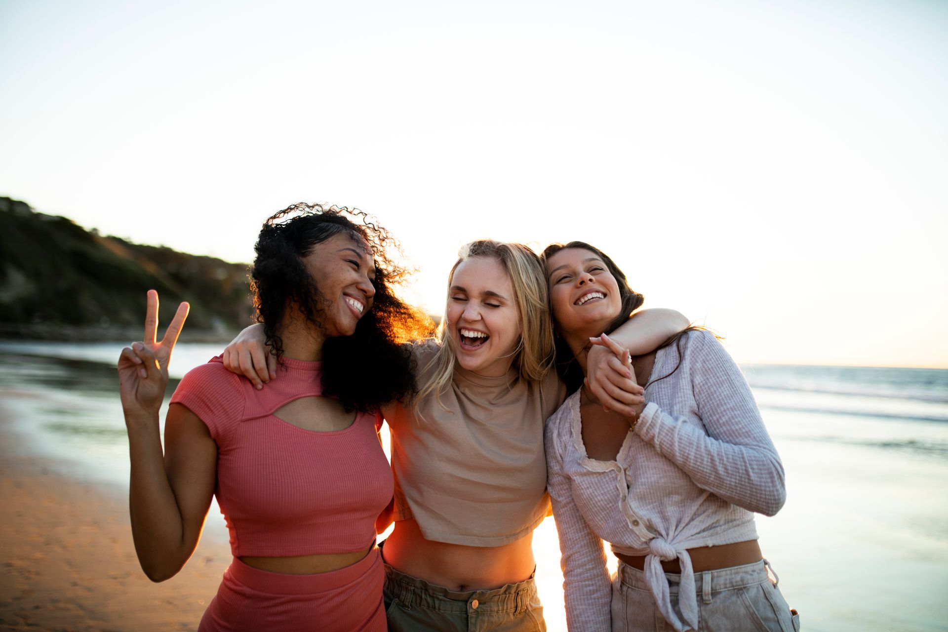 Three women having fun by the beach and enjoying a healthy life empowered by health screenings