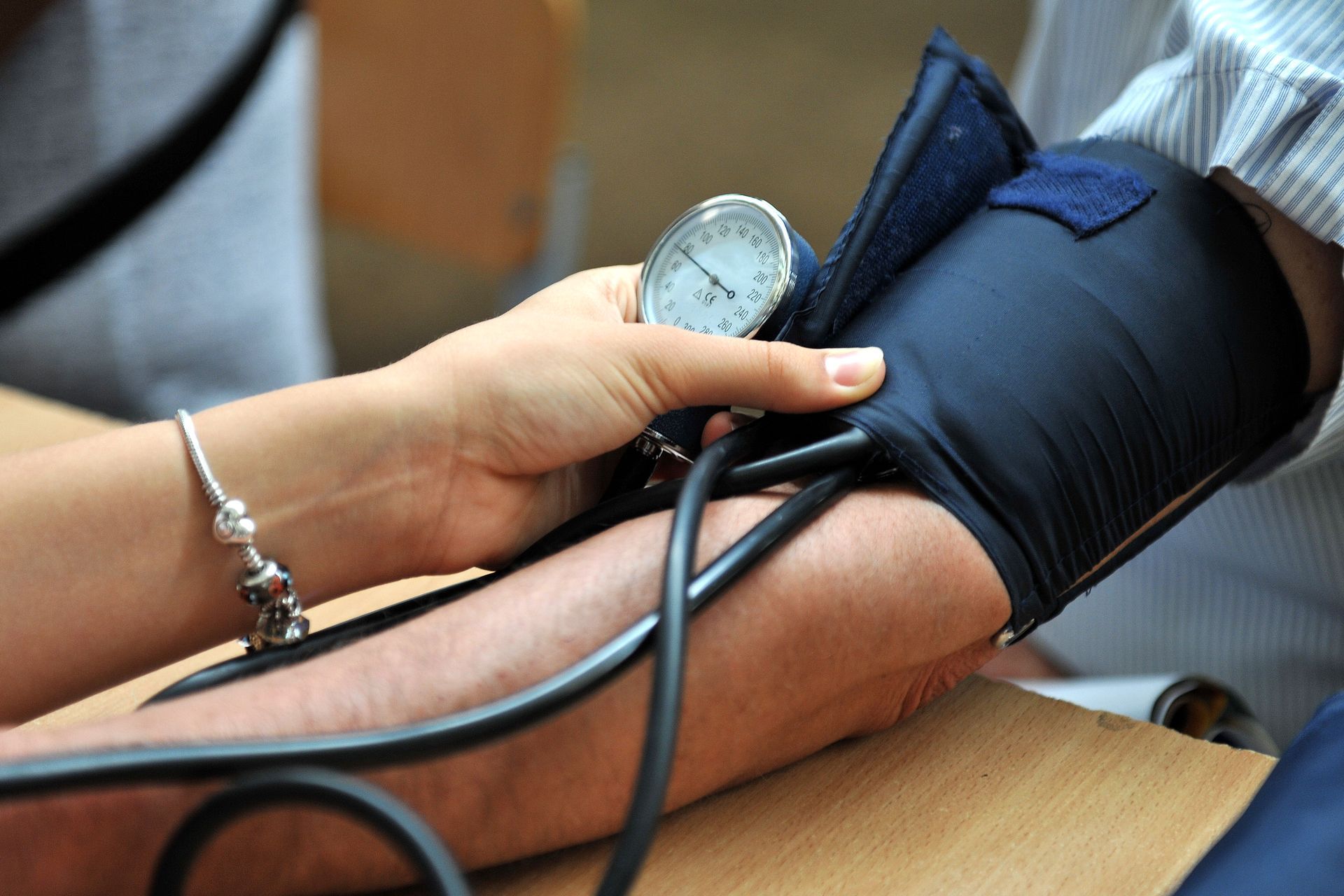 A caregiver helps a patient monitor and manage their high blood pressure levels.