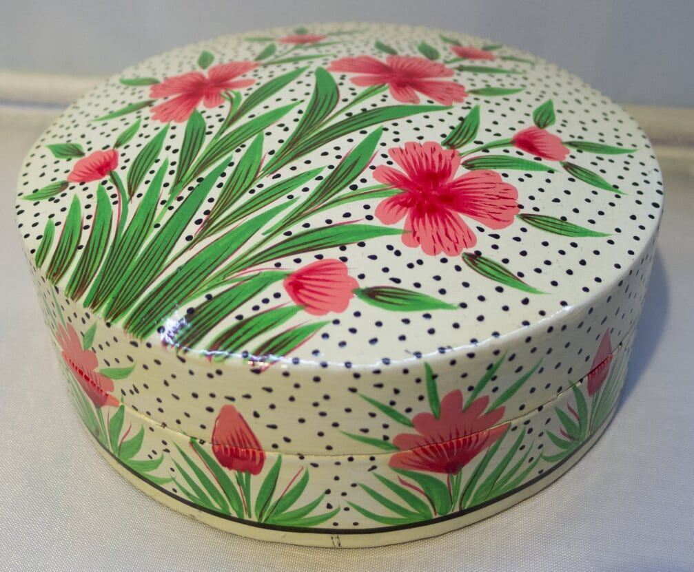 Round box with pink floral design on a polka-dotted cream background.