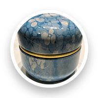 Round blue and white patterned container with a gold band.