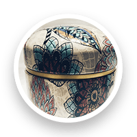 Round, decorative tin with floral design, blue, red, and gold accents.