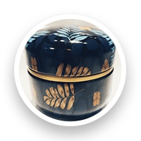 Dark blue round decorative box with gold leaf design.