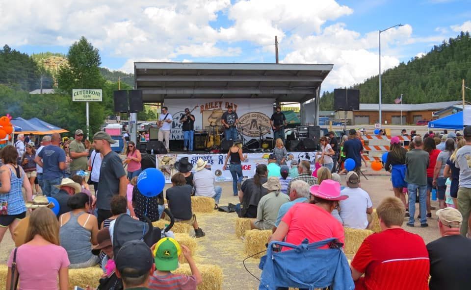 A crowd of people are sitting in front of a stage at a festival.