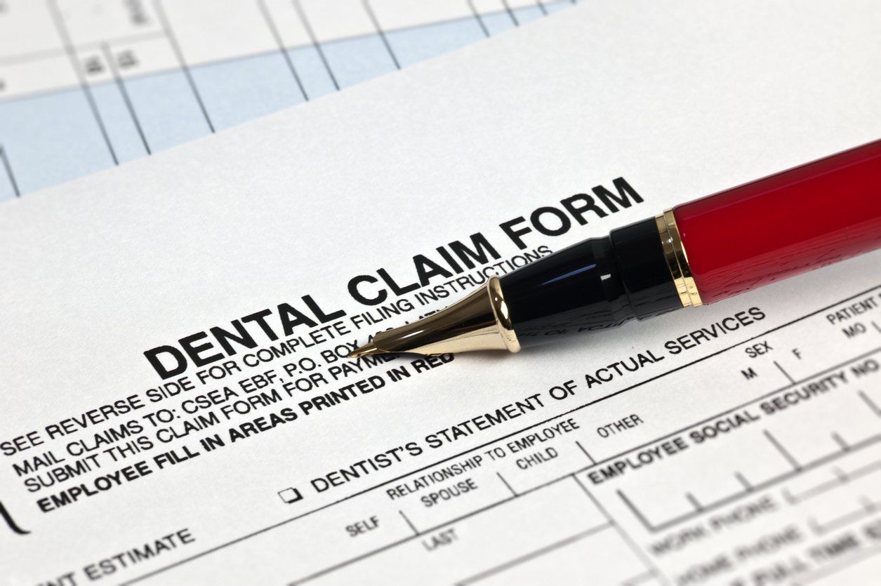 pen sitting on top of dental claim form