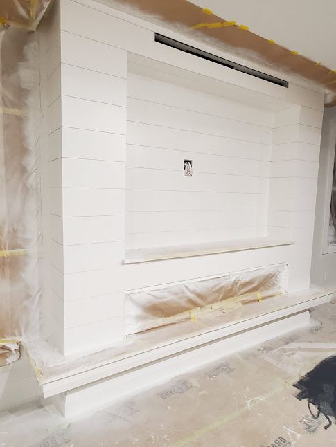 A living room with a fireplace and a television mounted to the wall.