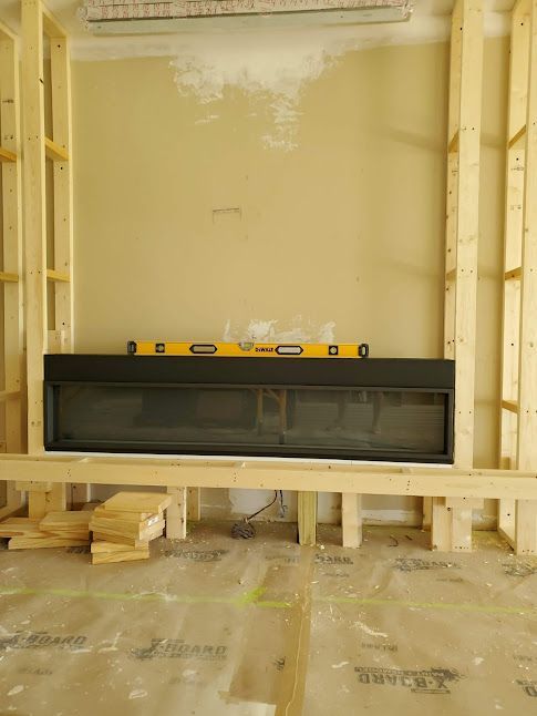 A fireplace is being built in a room with a yellow level.