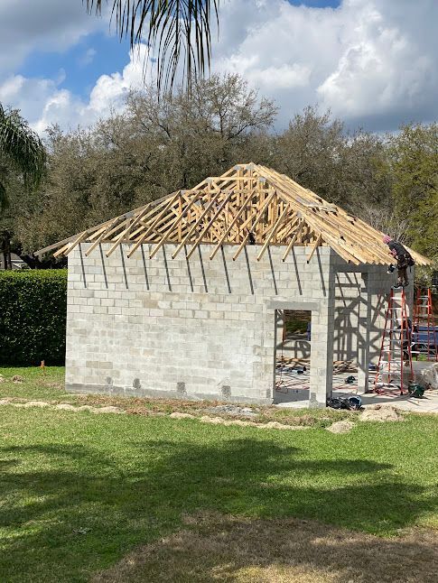 A brick building under construction with a wooden roof.