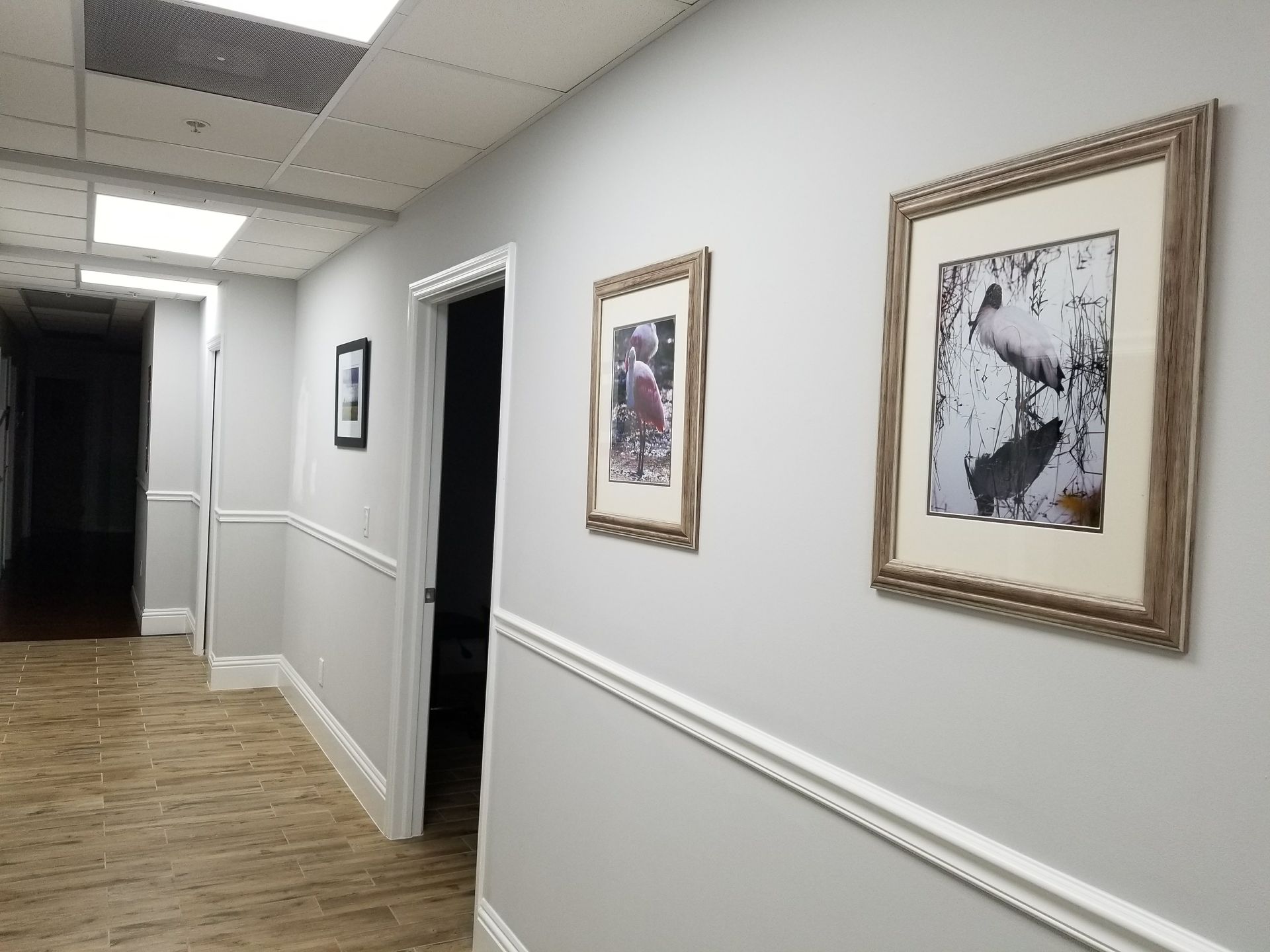 A hallway with two framed pictures on the wall.