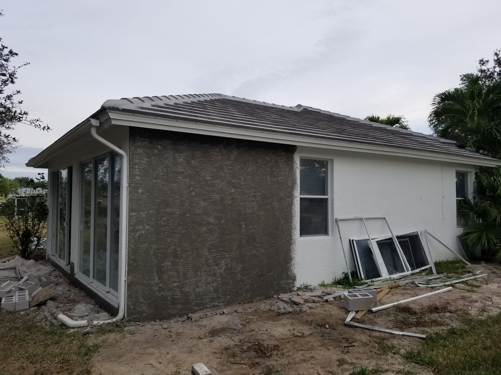 A small white house with a roof and a lot of windows