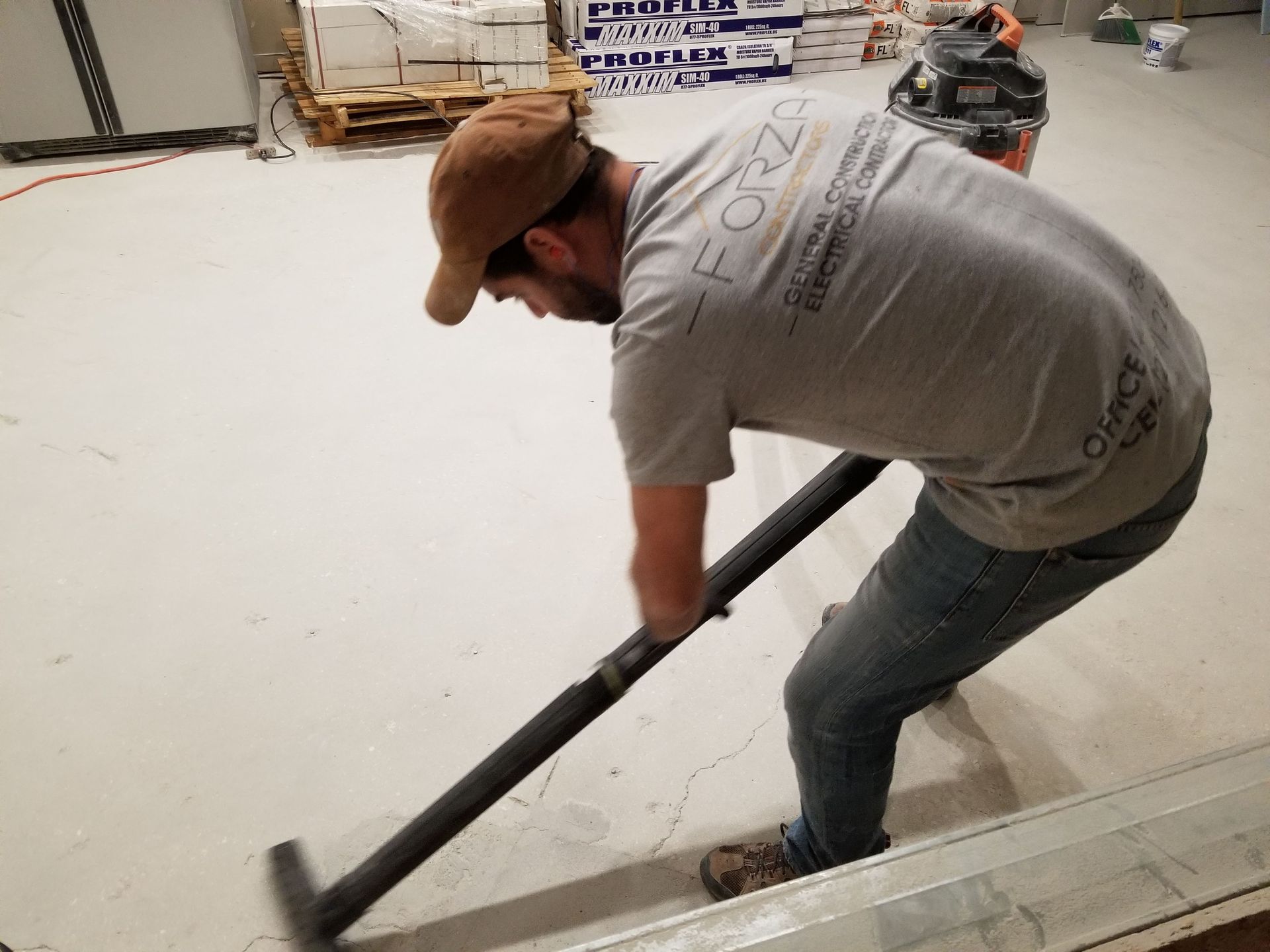 A man is using a vacuum cleaner to clean a floor.