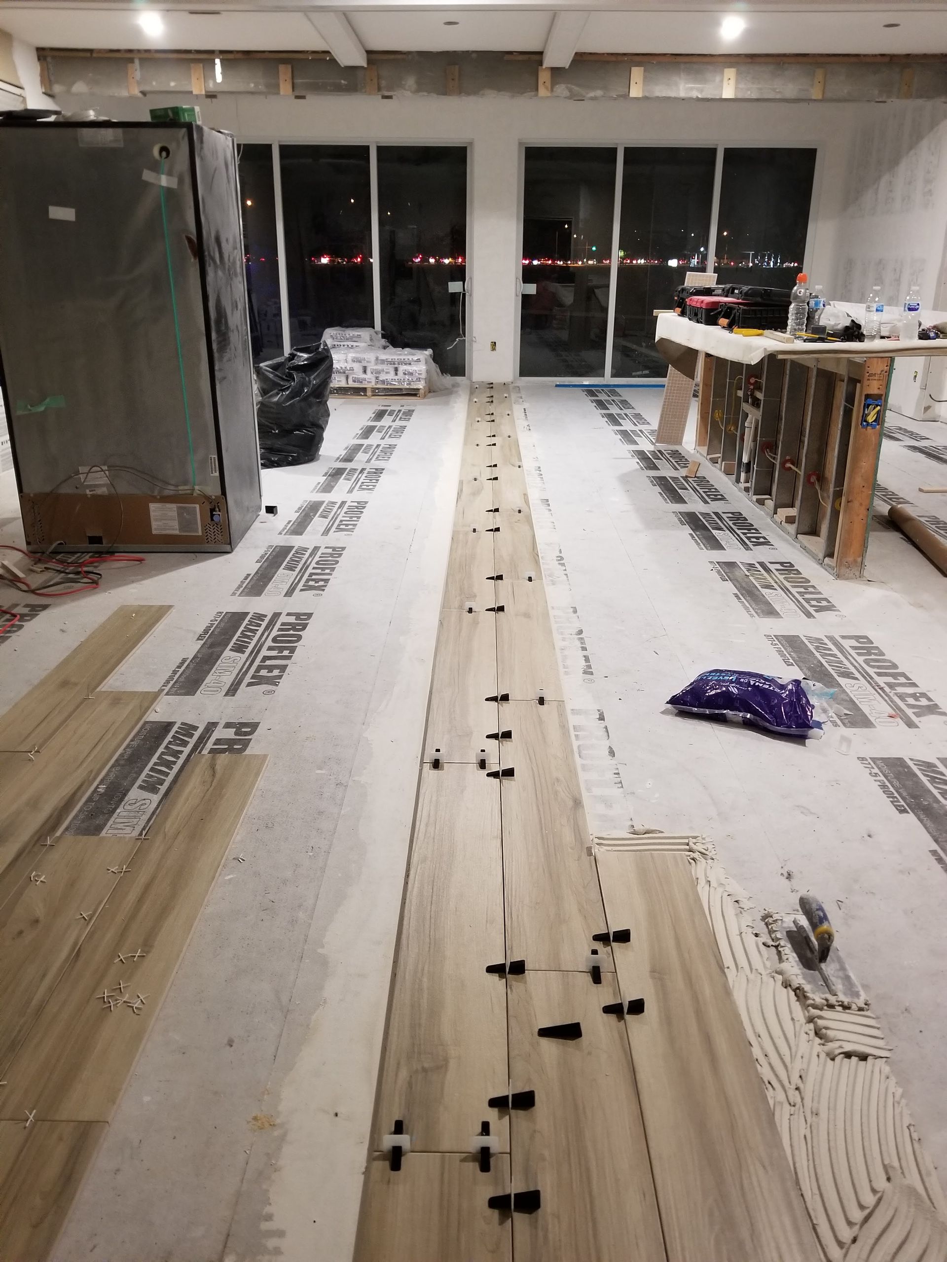 A long row of wooden flooring is being installed in a room.