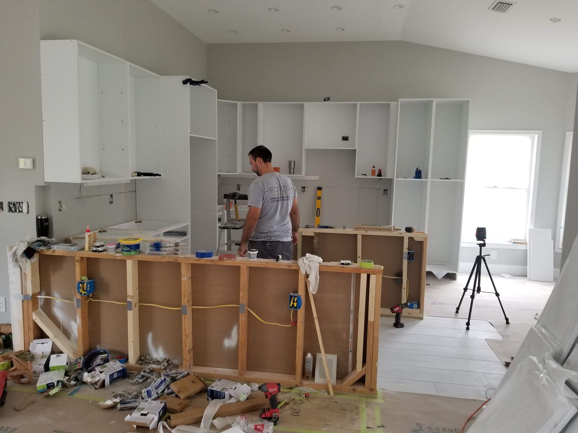 A man is standing in a kitchen under construction.