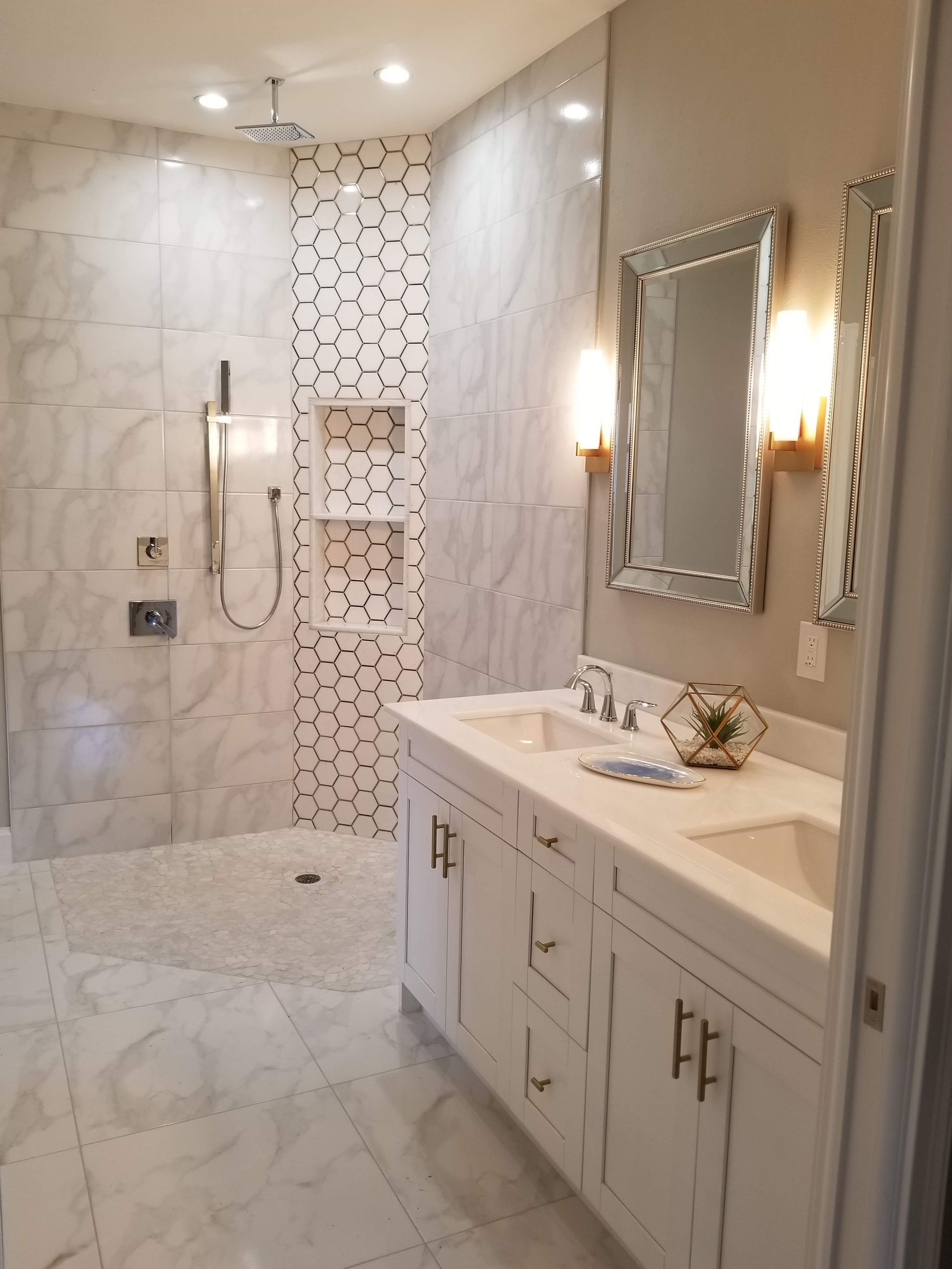 A bathroom with two sinks and a walk in shower