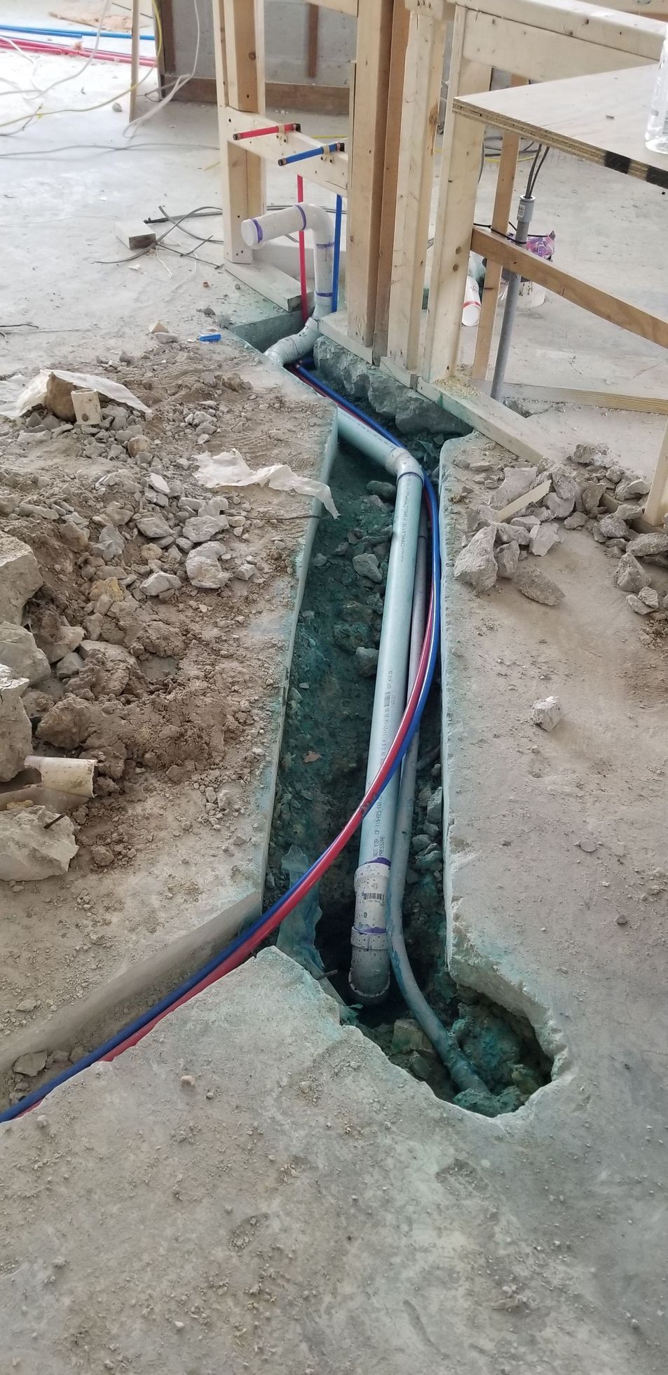 A hole in the floor with pipes coming out of it.