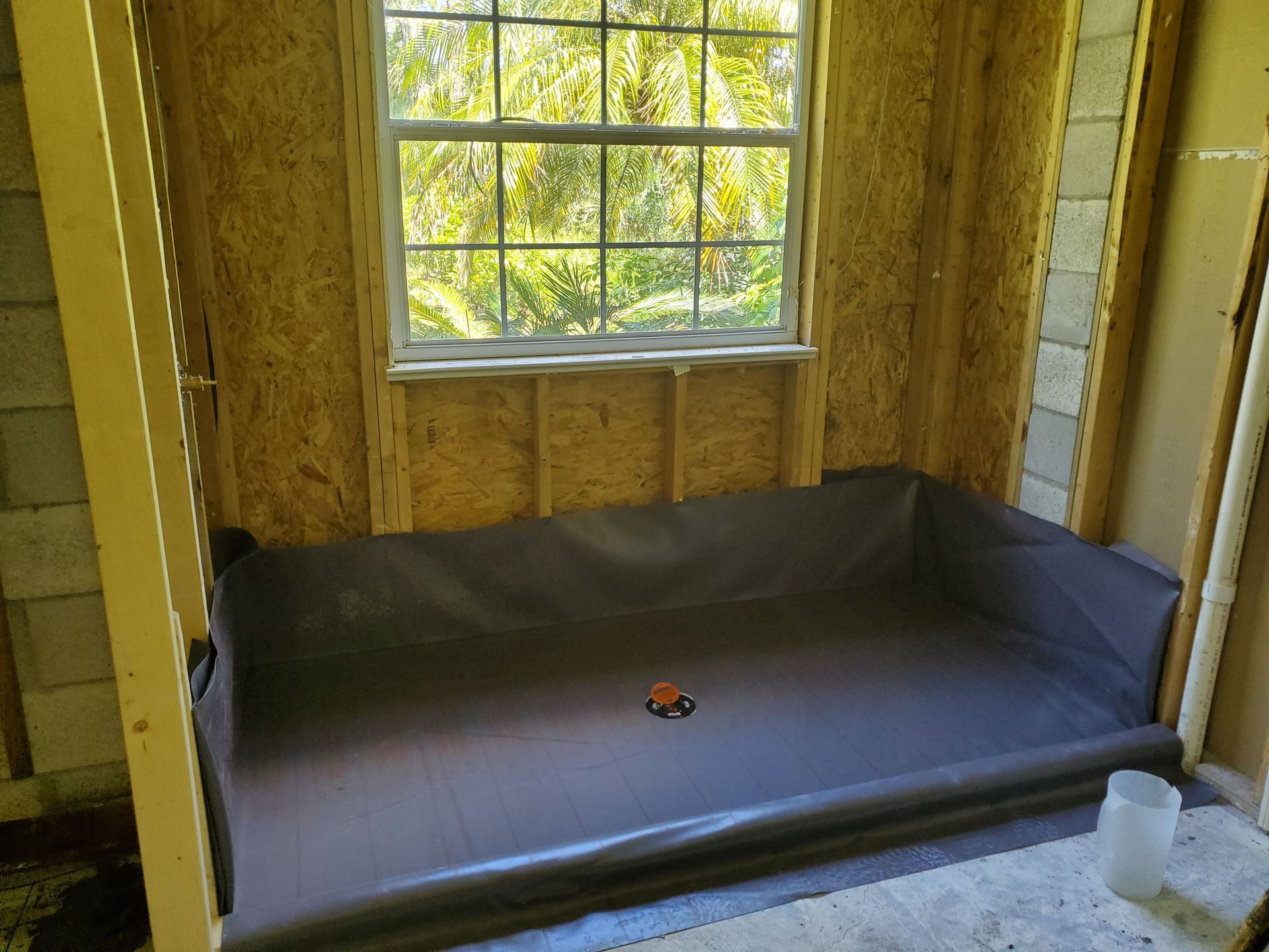 A shed with a window and a tarp on the floor.