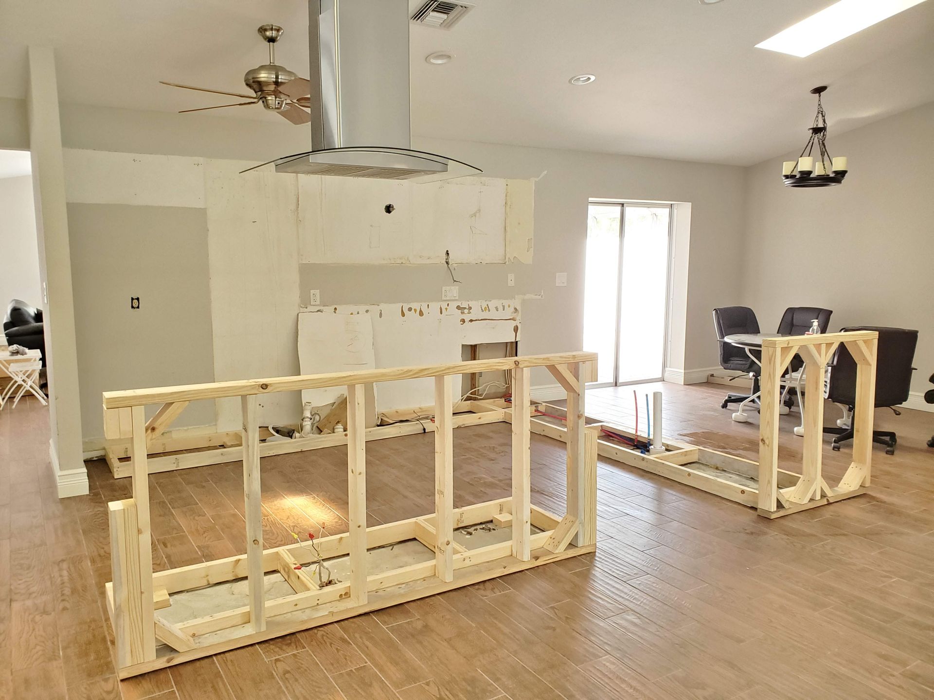 A kitchen under construction with wooden frames and a ceiling fan.