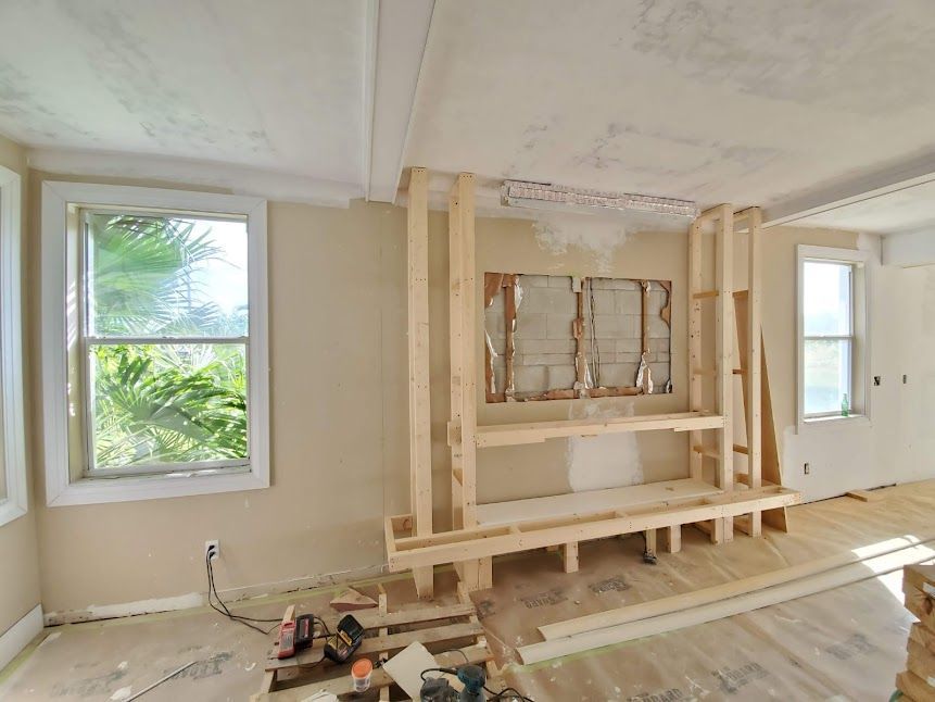 A living room with a fireplace being built in it.