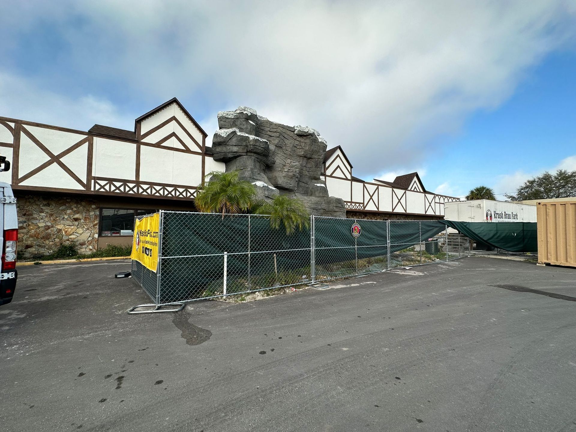 A van is parked in front of a building with a fence around it.