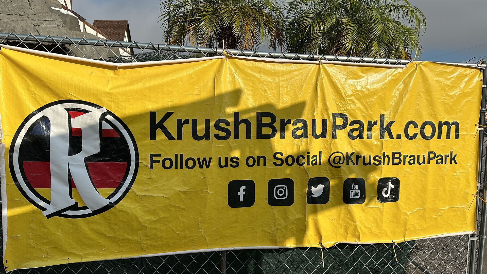 A yellow banner on a chain link fence says krushbraupark.com