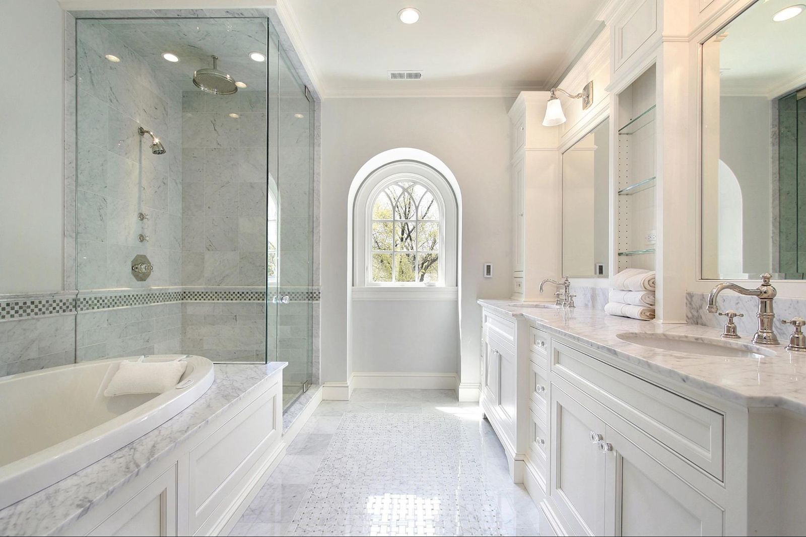 A bathroom with two sinks , a tub and a walk in shower.