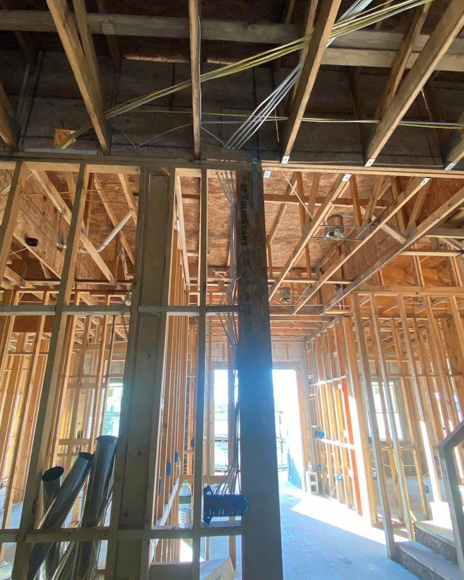 The inside of a building under construction with wooden beams and a ladder.