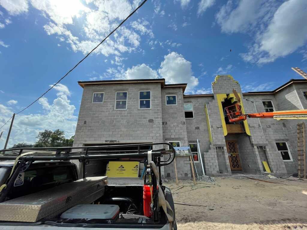 A truck is parked in front of a building under construction.