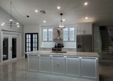 A kitchen with a large island and a refrigerator.