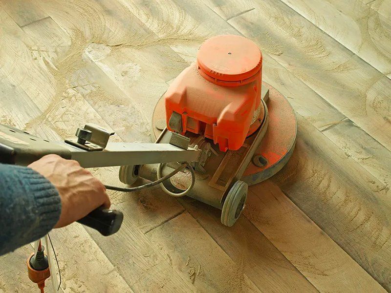 A person is using a machine to polish a wooden floor.