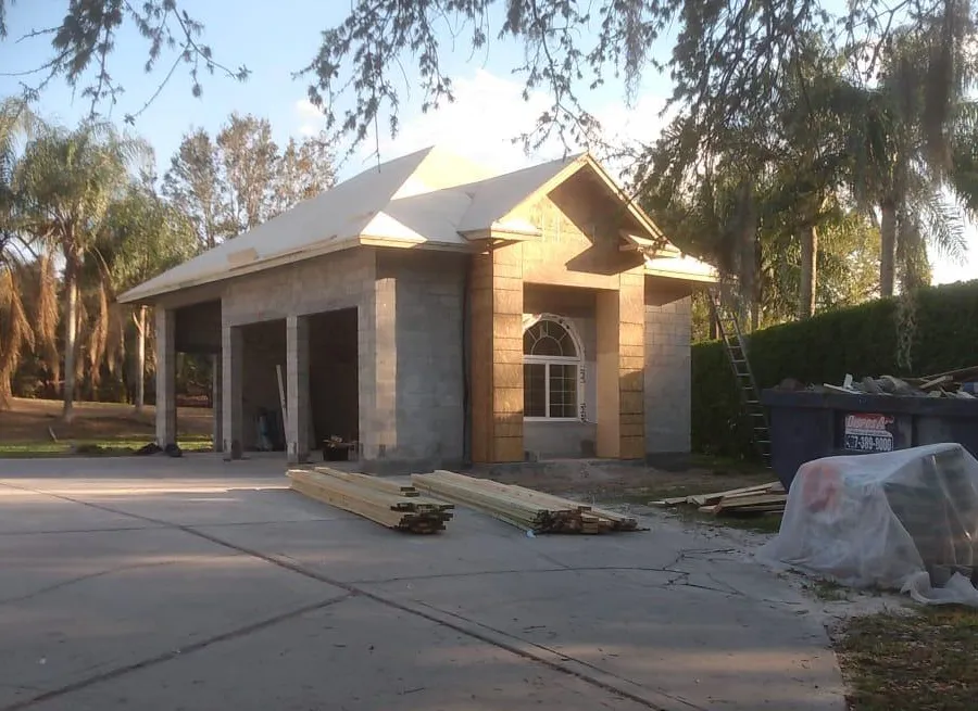 A house that is being built with a lot of wood in front of it