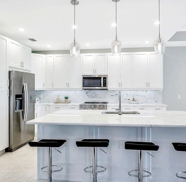 A kitchen with white cabinets and stainless steel appliances