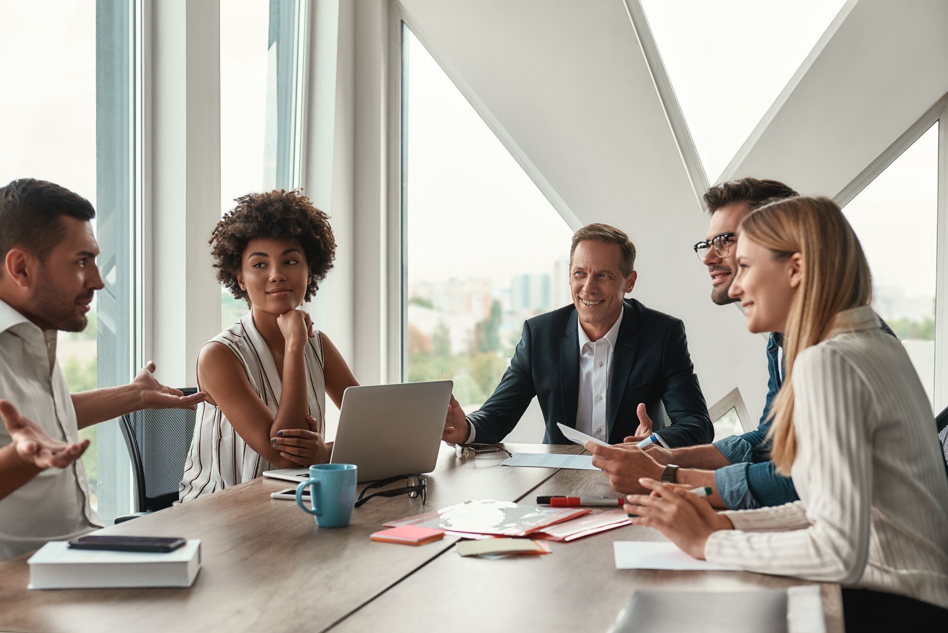 A group of people are sitting around a table having a meeting.