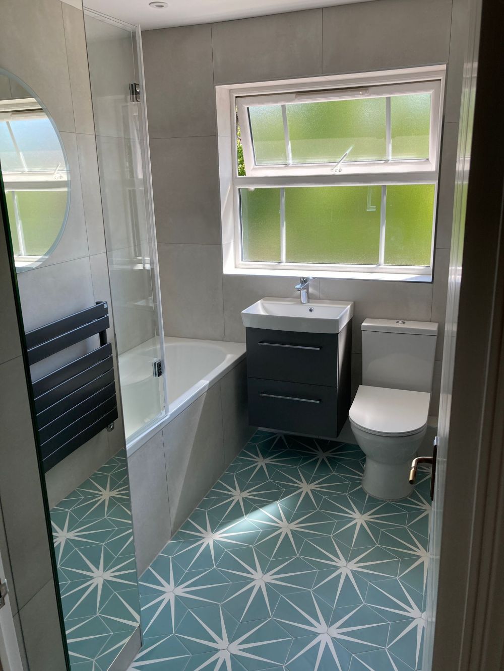 A bathroom renovated by Options Bath and Tile Studio. Featuring large format floor tiles and space-saving furniture.