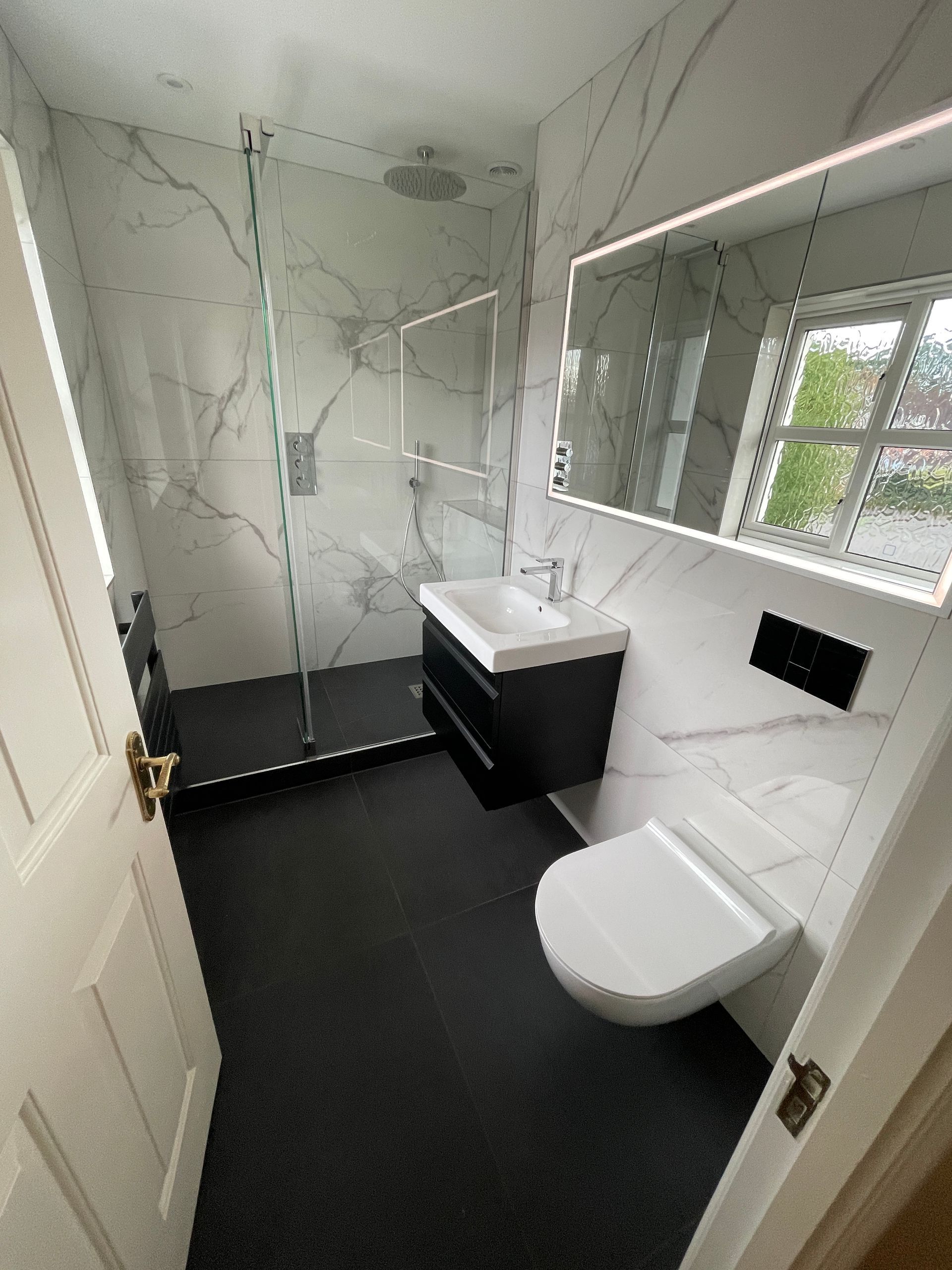 A modern, black and white bathroom that's fully tiled and fitted by Options Bath and Tile Studio, Berkshire.