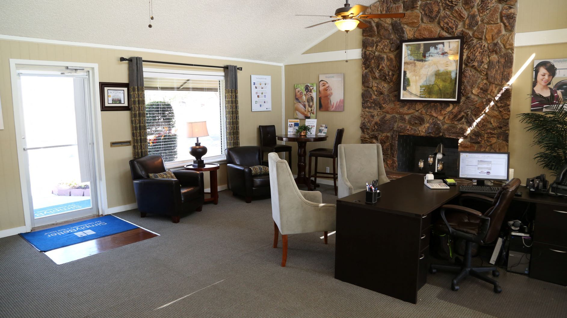 Office interior with seating area, desk, and stone fireplace.