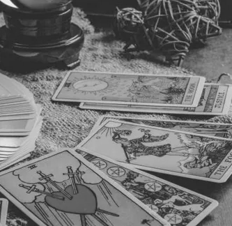 A black and white photo of tarot cards on a table.