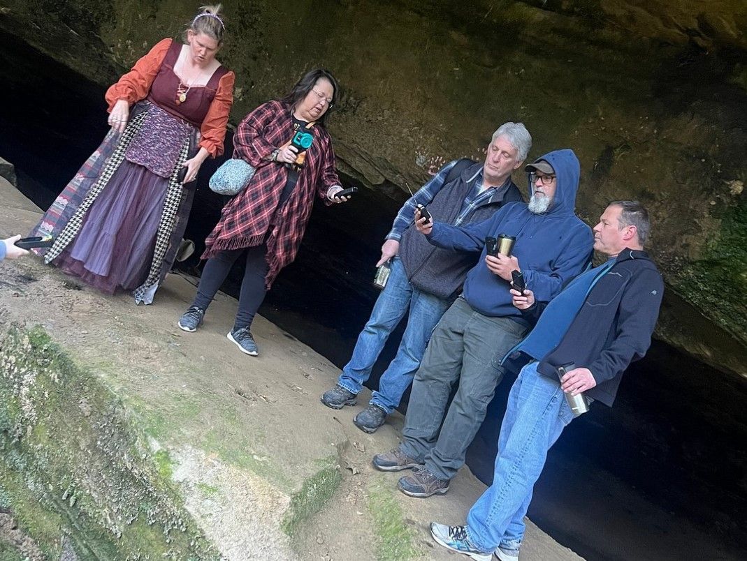 A group of people are standing next to each other in a cave.