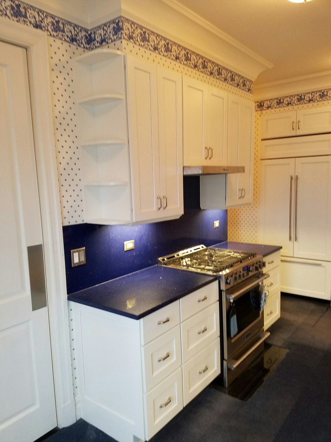 Navy blue kitchen remodel with navy countertops and white cabinets and new stove