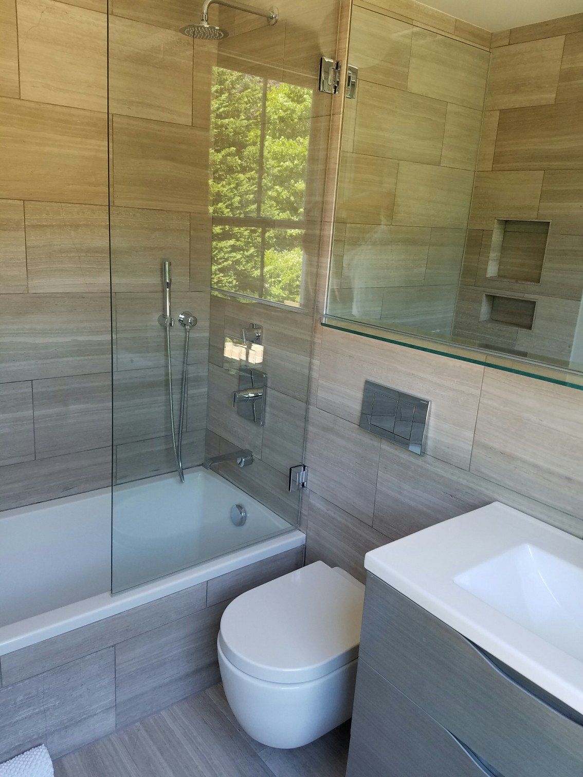 Bathroom remodel with shower bathtub that has gray walls and floors