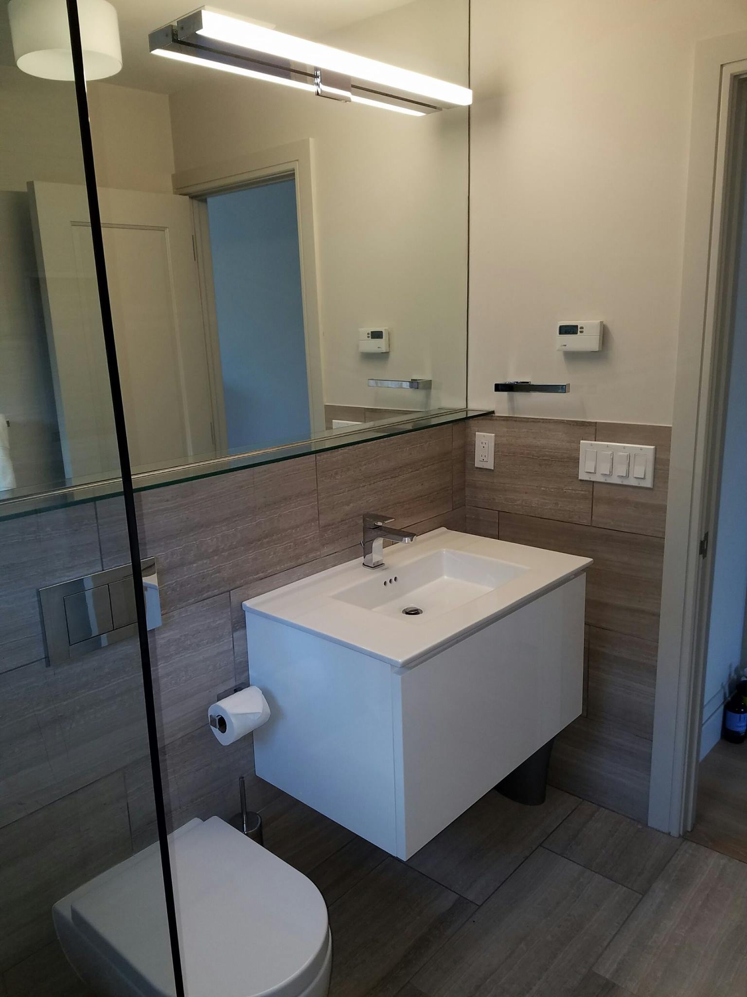 Bathroom remodel with gray wood floor and wall tiles
