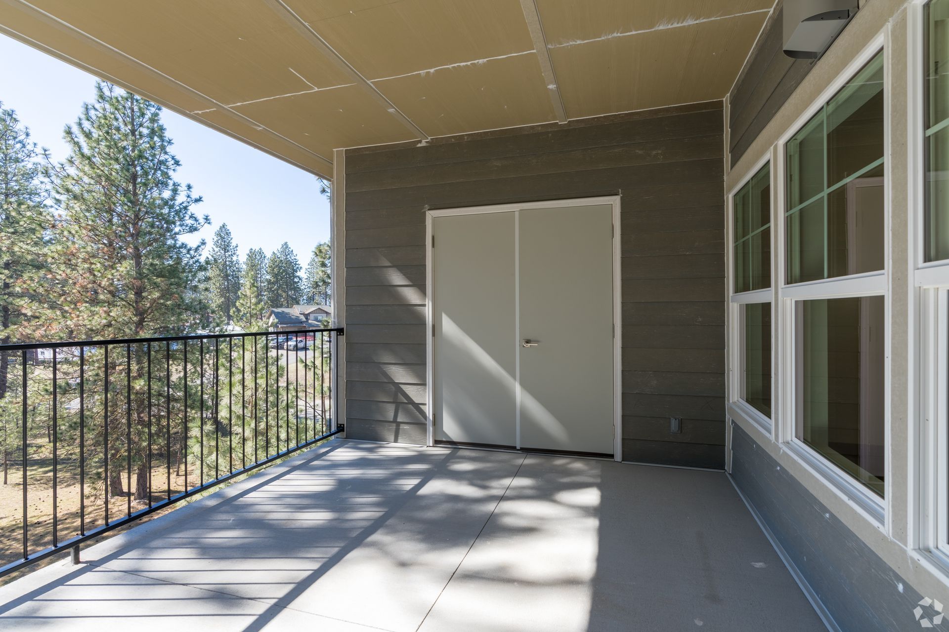 There is a balcony with a railing and a view of the trees.