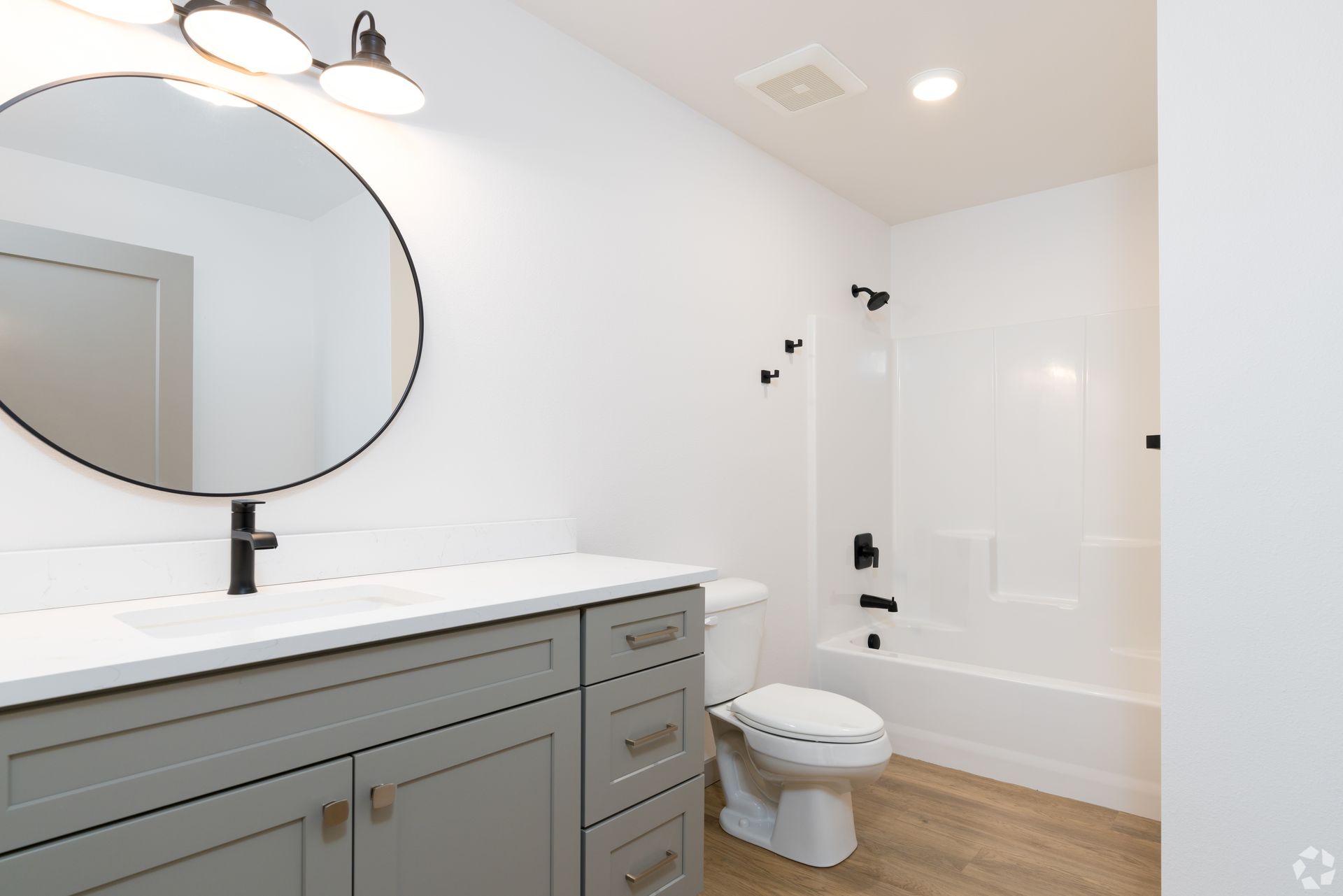 A bathroom with a toilet , sink and mirror