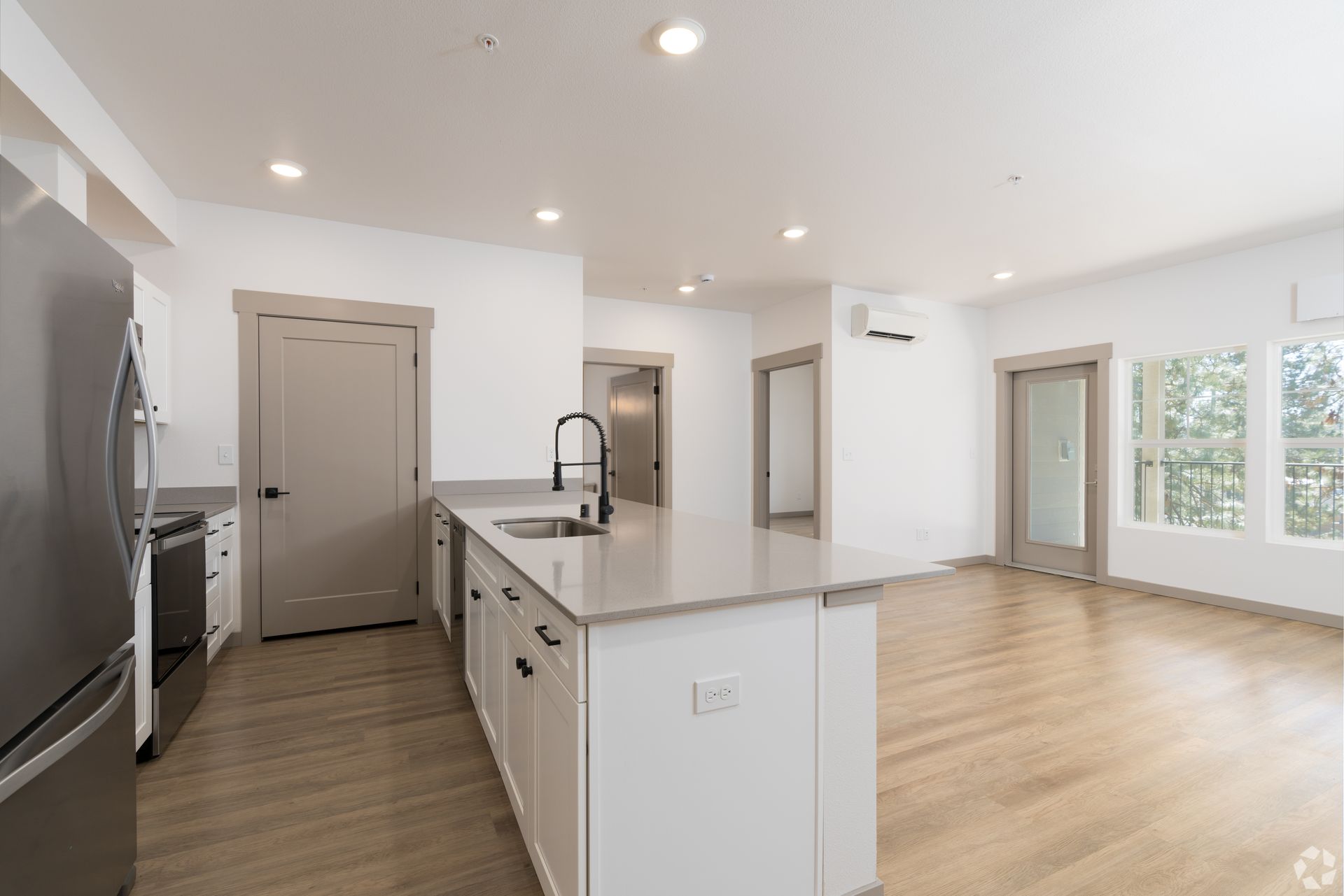 An empty kitchen with a large island in the middle of the room.